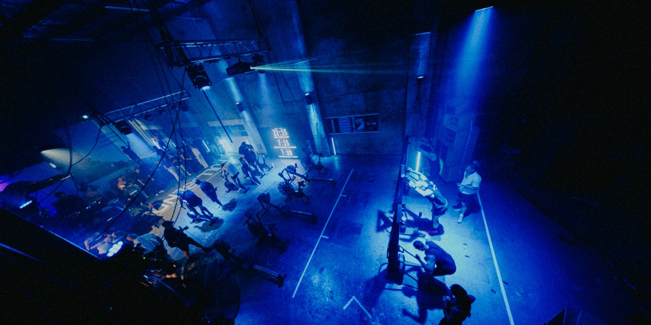 The floor at REVL Underground, Sydney, racers on the ergs under blue light